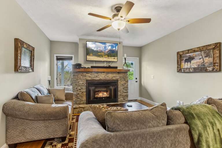 Lower Level Den Living Space with Comfortable Couches, TV, and Gas Log Fireplace
