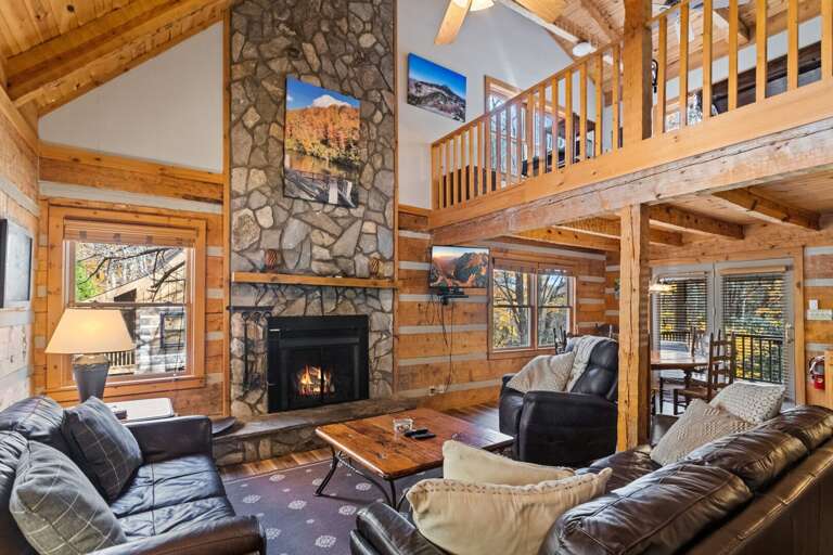 Stacked Stone Gas Fireplace and Leather Furniture in the Living Room with Loft Above Stacked Stone Gas Fireplace and Leather Furniture in the Living Room with Loft Above