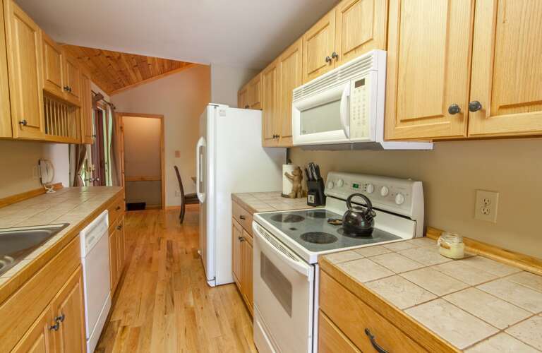 Convenient Galley Style Kitchen with Plenty of Counter Space, Range/Oven, Microwave and Dishwasher