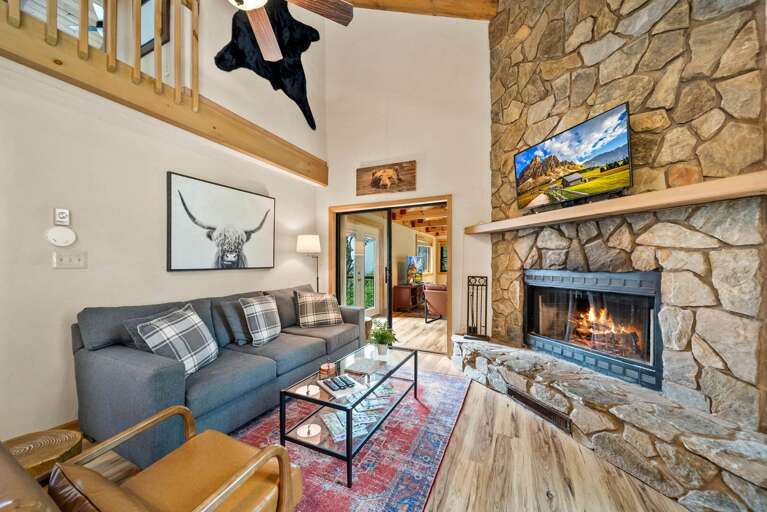 Cozy Living Room Stacked Stone Gas Fireplace Adjacent to the Den Separated by Glass Sliding Doors