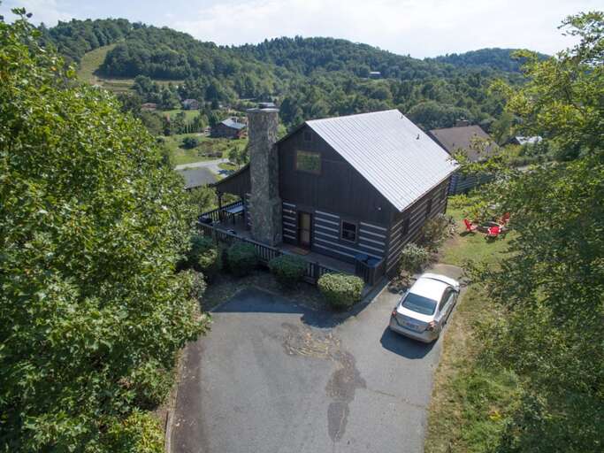 Aerial view looking at parking area and front of home