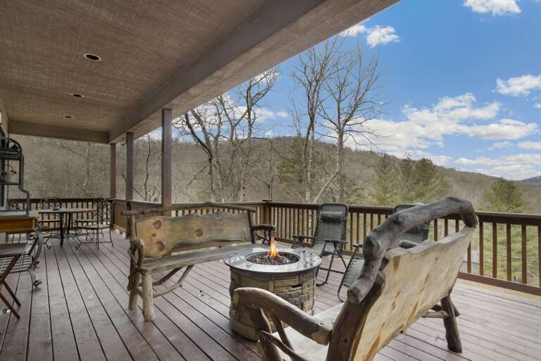 Rear Deck on Main Level with Central Fire Feature, Live Edge Benches, Gas Grill, and Two Outdoor Dining Tables