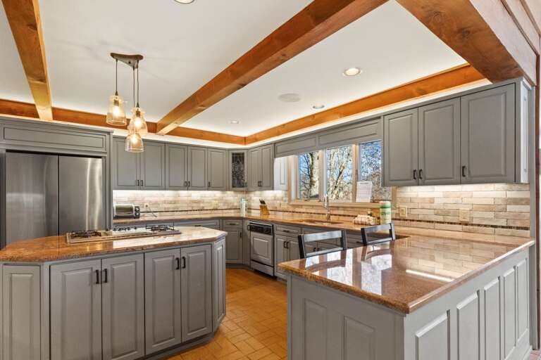 Along with Heated Brick Floors, the Kitchen Features a Gas Cooktop, Stainless Steel Appliances, and Accent Lighting