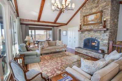 Living Room with Stacked Stone Fireplace and Chandelier