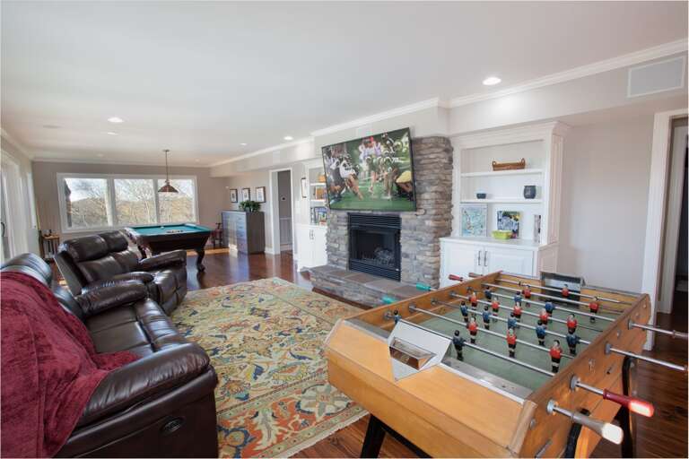 Living Area on Third Floor with Foosball, Stone Fireplace, and Flat Screen TV