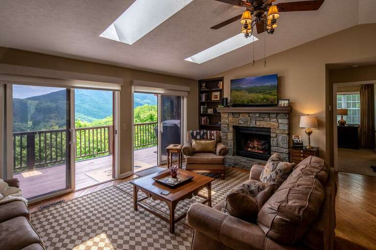 Great Room with leather furniture and stone fireplace and view