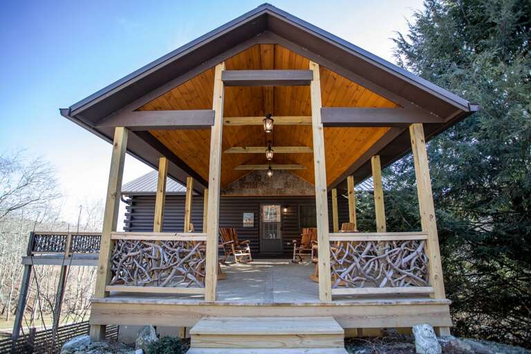 Custom Front Porch with Gabled Roof, Chandeliers, Branch Balustrade, and Log Hewn Rocking Chairs Custom Front Porch with Gabled Roof, Chandeliers, Branch Balustrade, and Log Hewn Rocking Chairs