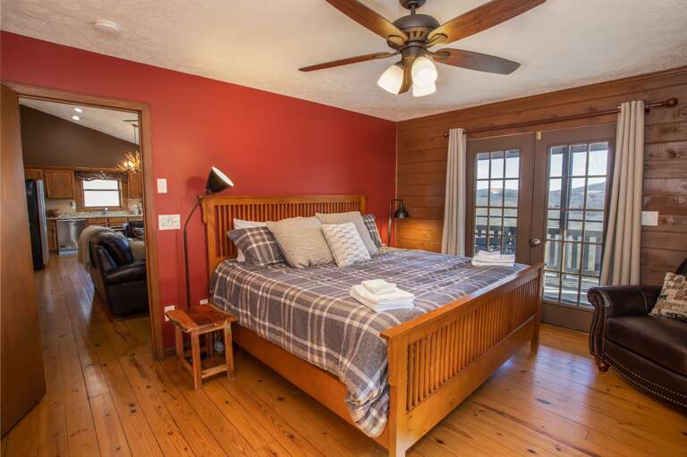 Master Bedroom Suite on Main Level with Glass Doors which Lead Out onto Covered Deck, and which Frame Mountain Views Master Bedroom Suite on Main Level with Glass Doors which Lead Out onto Covered Deck, and which Frame Mountain Views