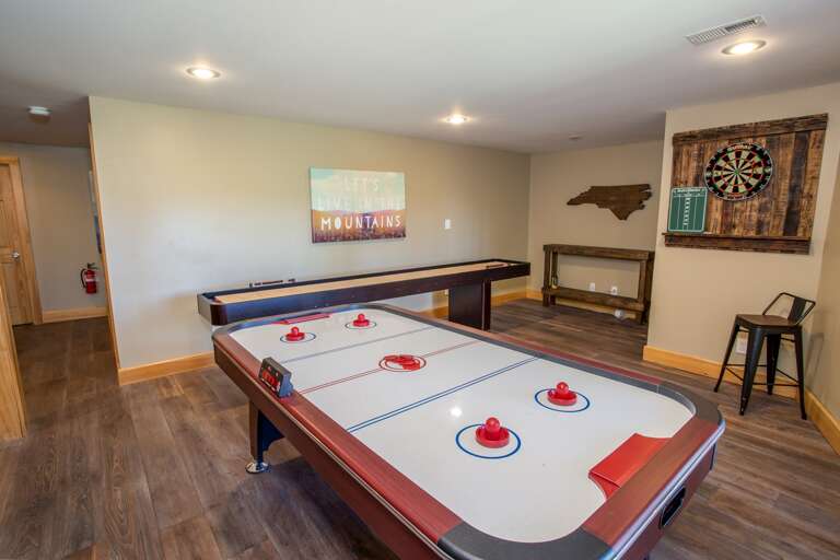 Game Room with Air Hockey and Shuffleboard Tables, as well as Dart Board.