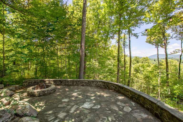 The Wood Burning Fire Pit shows off Gorgeous Timeless Stonework, *Plastic Adirondack Seating Not Pictured*