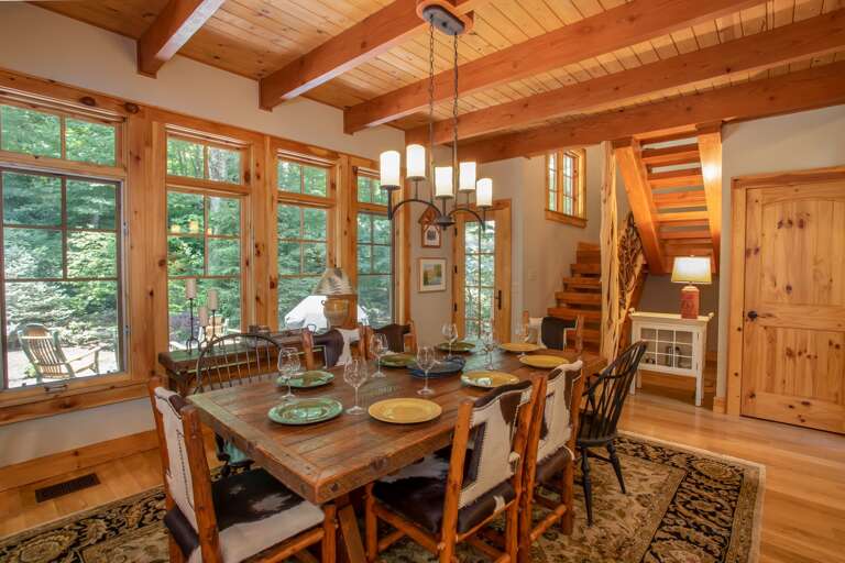 Dining Table in front of Wall of Windows framing Abundant Nature!