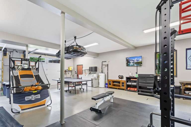 Garage Gym and Game Room with Bench, Dumbbells, Bands, Rack, Rubber Mat Floor and More Garage Gym and Game Room with Bench, Dumbbells, Bands, Rack, Rubber Mat Floor and More
