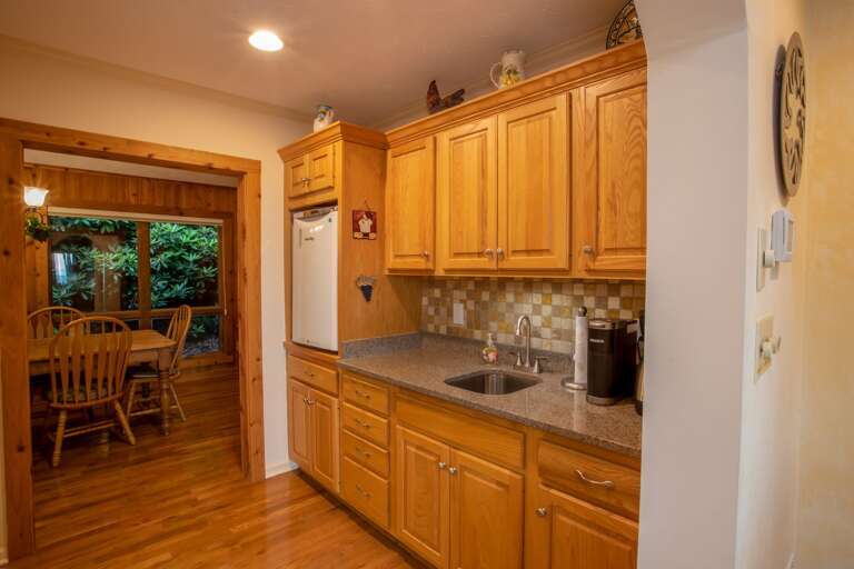 Granite Bar and Coffee Station adjacent to Kitchen, with Sink and Mini Fridge