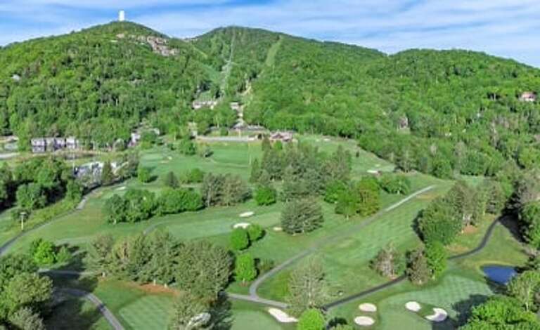 Aerial Views of Sugar Mountain during Summer, boasting their 18-hole Golf Course, and the Ski Slopes behind!