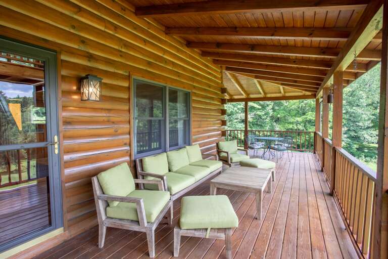 Comfy Outdoor Living Furniture on Huge Covered Front Porch, includes Sofa flanked by two Chairs - each with an Ottoman