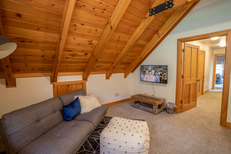 Cozy Couch and Ottoman along with HD Smart TV in Upstairs Bedroom and Game Table