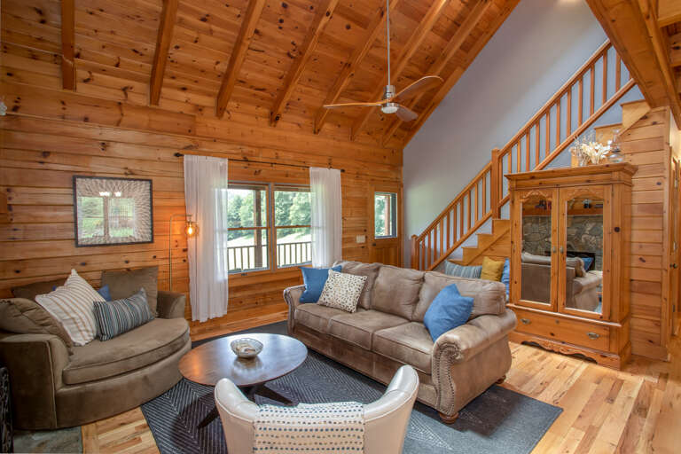 Great Room with Comfortable Furniture and Leather Chair,  Wood Floors, and Vaulted Tongue-and-Groove Ceilings with Exposed Beams! Armoire is stocked with games and puzzles.