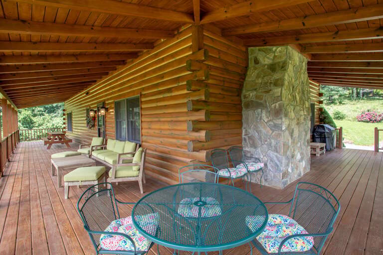 Huge Covered Front and Side Deck with Comfy Seating, two Outdoor Dining Tables, and a Gas Grill!