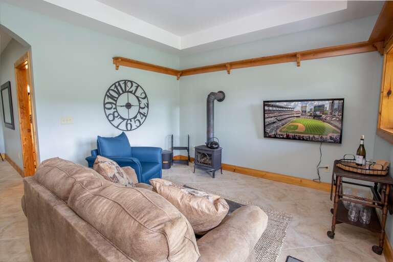 Lower Level Den withCozy Furniture, Woodstove Fireplace, and Huge HD Smart TV