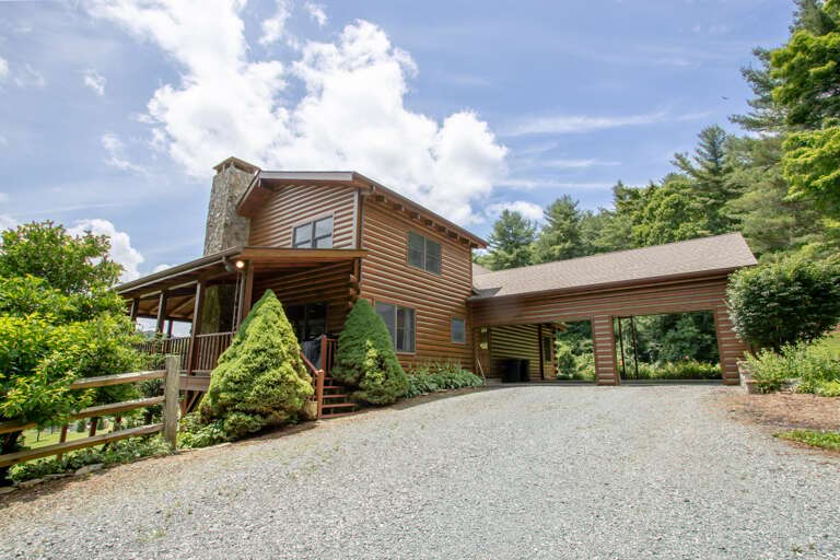 Rear Side Exterior, shows large level Parking Area and rear Two-Car Carport