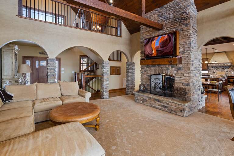 Double Sided Stacked Stone Wood Burning Fireplace with Mounted Flat Screen TV