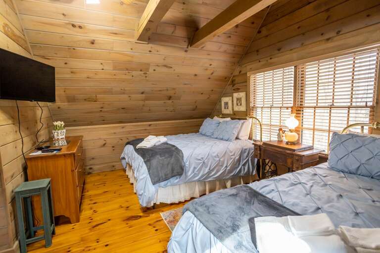 Exposed Beams and Large Windows in Queen Bedroom with  a TV