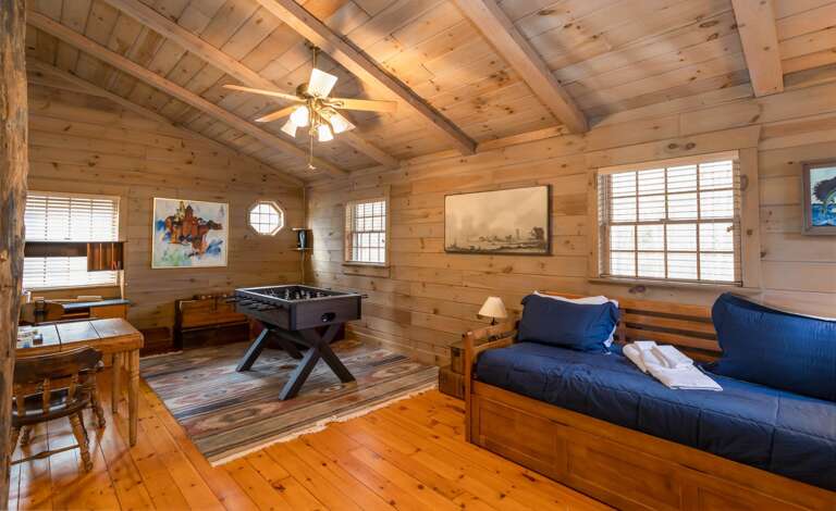 Upper Level Loft has a Wooden Table, Foosball and Twin Day Bed with a twin trundle below (sleeps 2).