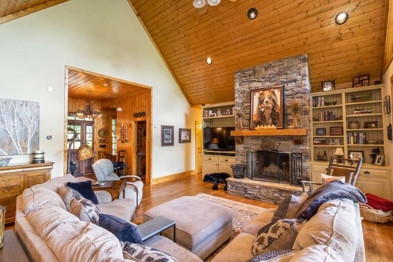 Main Floor Living Room has Stacked Stone Wood Burning Fire Place and TV