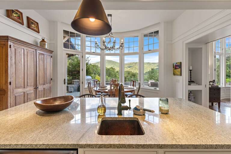 Kitchen Island with Copper Basin Sink and Dining Room Surrounded by Windows