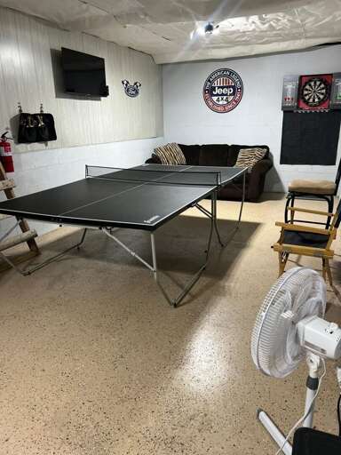 Basement Game Room with TV, Couch, Ping-Pong Table, and Dart Board Basement Game Room with TV, Couch, Ping-Pong Table, and Dart Board