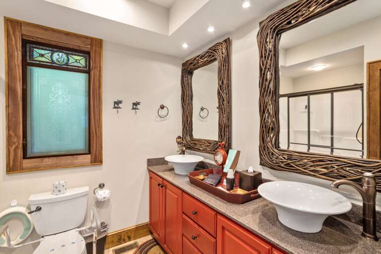 Lower Level Shared Hallway Bathroom Has Double Vanities and Step in Shower
