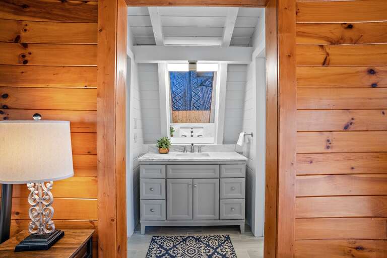 Single Open Vanity in Bathroom with Closet to Left Additional Private Vanity and Full Bath to the Right.