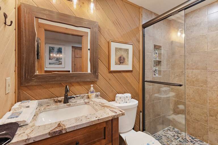 Stone and Tile Glass Door Shower in the Lower Level Bathroom