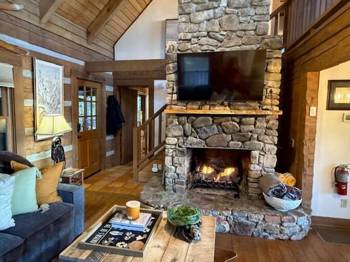 Wood-Burning Stone Fireplace and Mounted TV in the Living Room