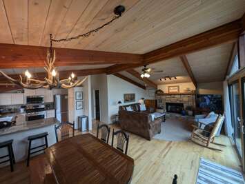 Dining Table is Adjacent to Living Room with Custom Chairs and Bench Seating