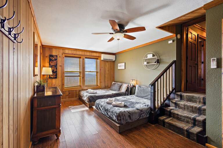 Step Down from the Lower Level Hallway into a Bedroom with Two Double Beds