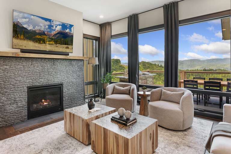 Stacked Stone Gas Log Fireplace, TV, and Wall of Windows with Long Range Views Stacked Stone Gas Log Fireplace, TV, and Wall of Windows with Long Range Views