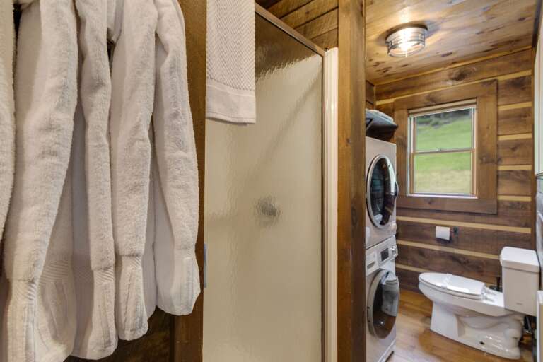 Main Floor Shared Bathroom with Step-in Shower and Laundry Machines