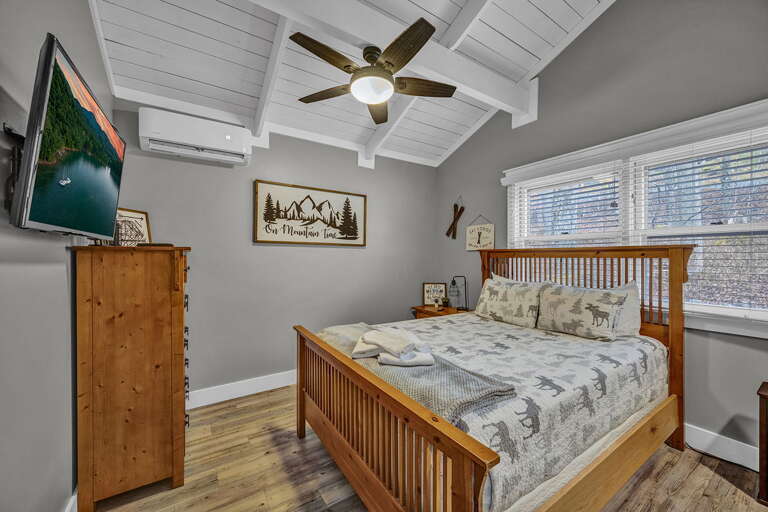 Main Level Bedroom With a Queen Bed and Smart TV