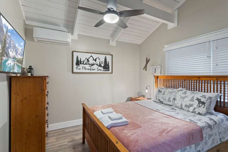 Main Level Bedroom With a Queen Bed and Smart TV