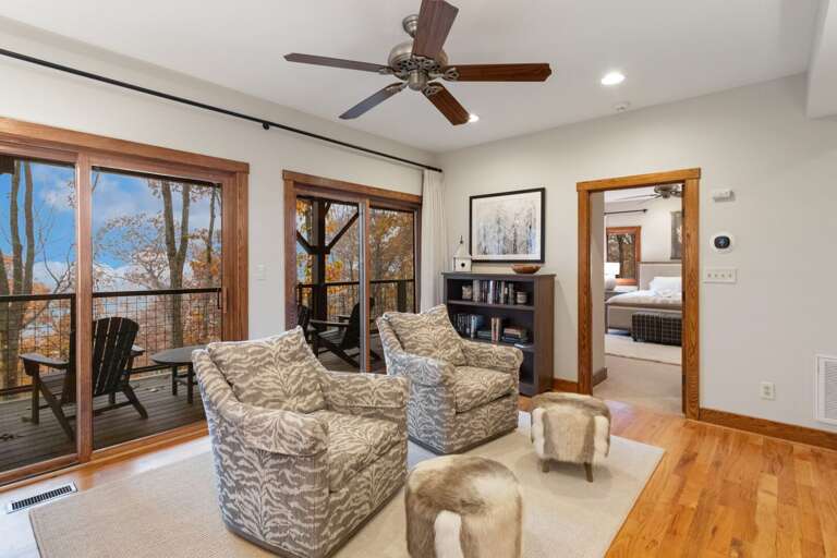 Middle Level Sitting Area with Access to the Back Deck with Adirondack Chairs, a Hammock, and Corn Hole Boards