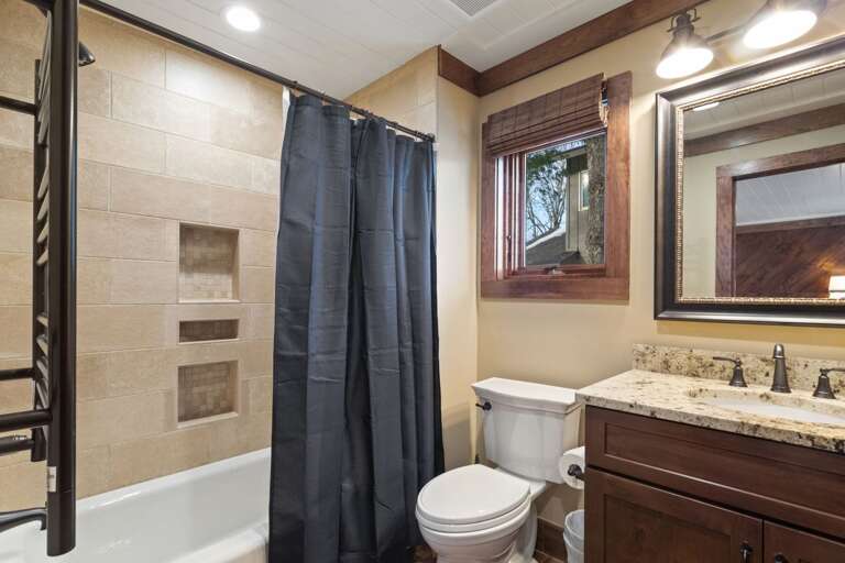 Ensuite Bathroom in the Main Floor King Bedroom with Tiled Tub and Shower Combo