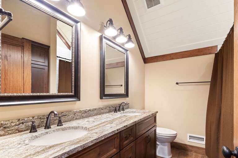 Upper Level Shared Hallway Bathroom with Double Vanities and Tub Shower Combo