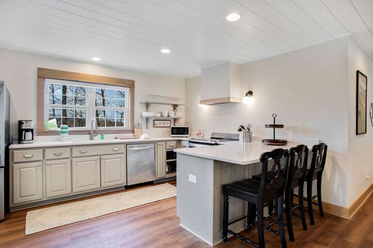 Bright Kitchen with Stainless Steel Appliances and Bar Seating for Three