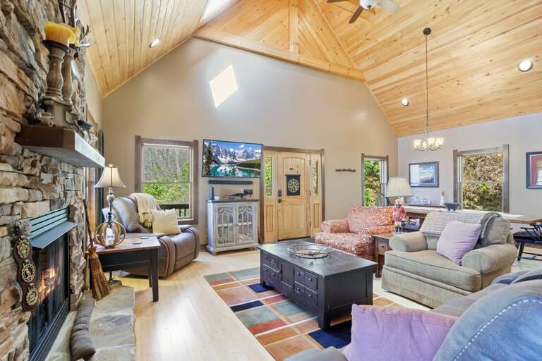 Living Room With Vaulted Ceiling And Stone Fireplace