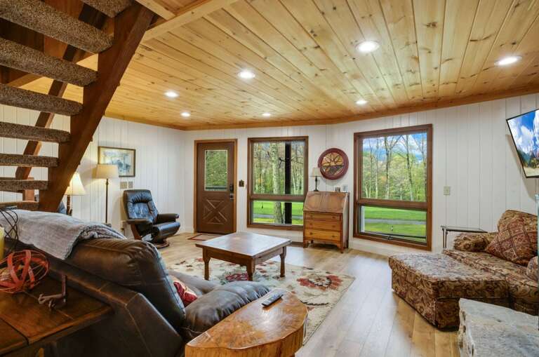 Main Floor Living Room with Wood-Burning Fireplace and TV