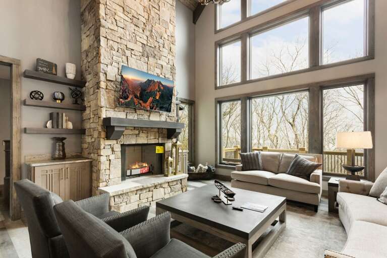 Main Floor Living Room with a Wall of Windows, Wood Burning Fireplace and TV