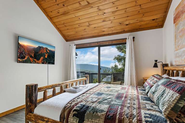 Main Floor Master Bedroom with King Bed, TV, and Deck Access