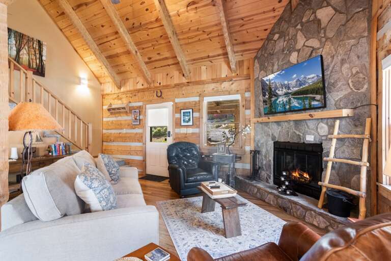 Stacked Stone Wood Burning Fireplace, Mounted TV and Floor to Ceiling Wood