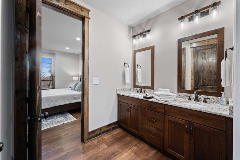 Vacation Rental View Showing Bathroom Leading To Bedroom, Featuring Wooden Accents And Mirrors